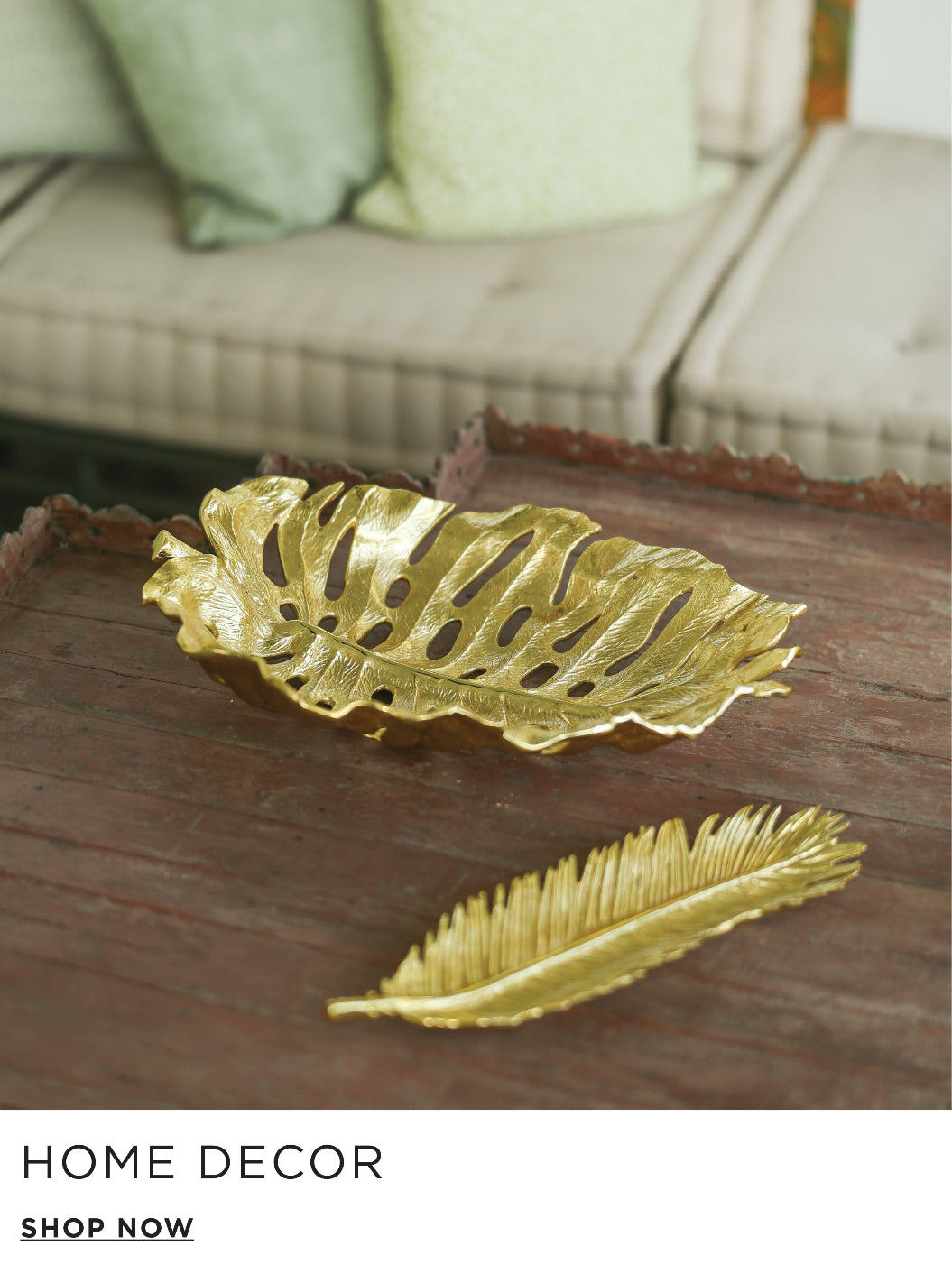 Gold leaf-shaped decorative items on a wooden surface with a couch in the background.