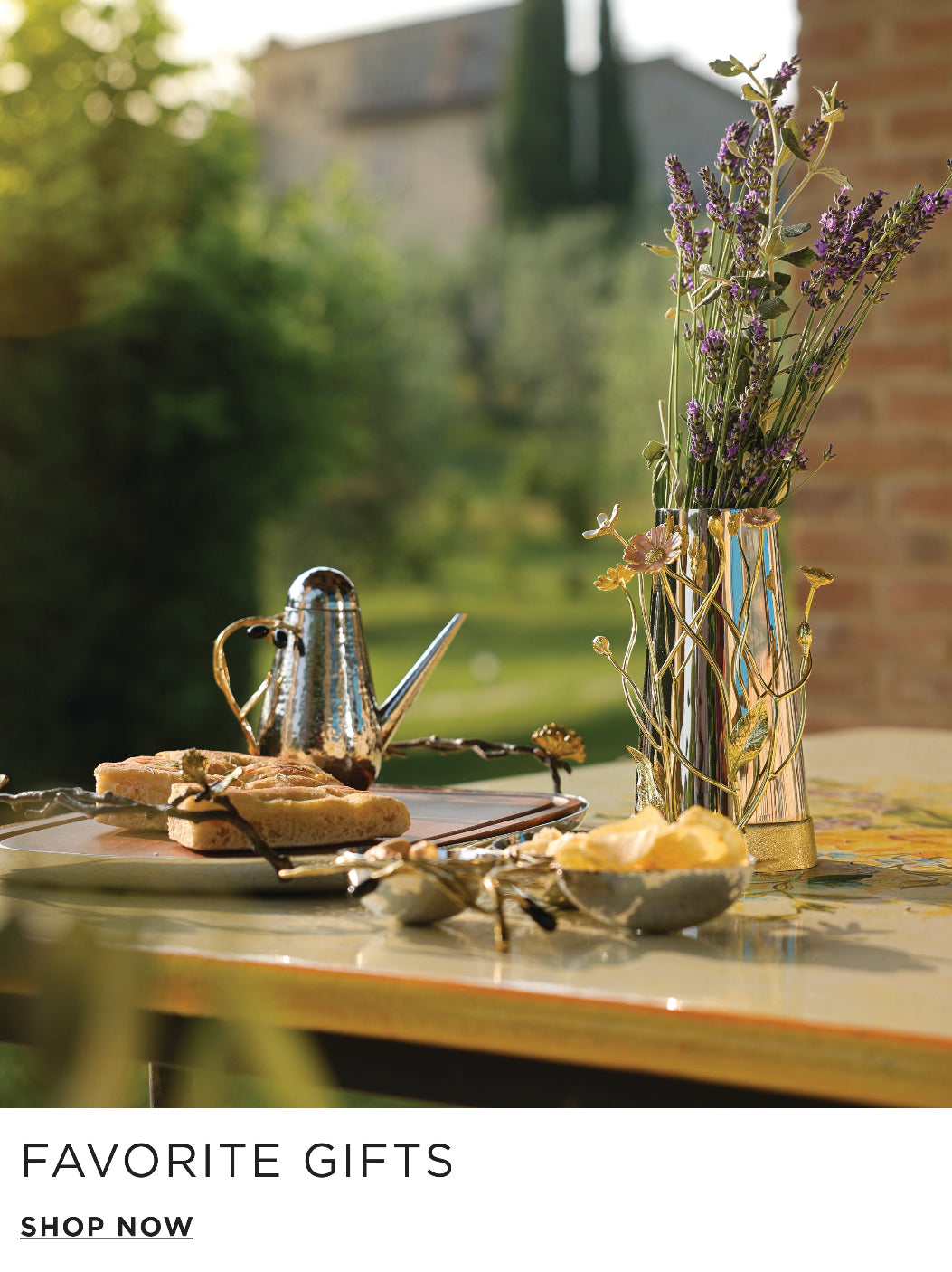 Table with teapot, cookies, and vase of flowers with 'Favorite Gifts' text and 'Shop Now' button.